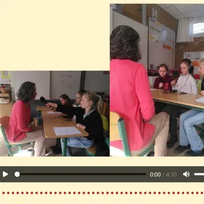 Man sieht Kinder mit einem Mikrophon, die eine Lehrerin interviewen.