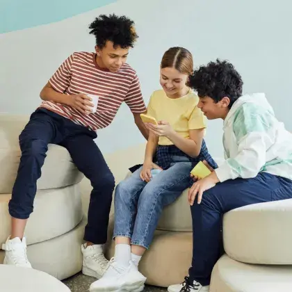 Man sieht drei Kinder vor einem Handy.